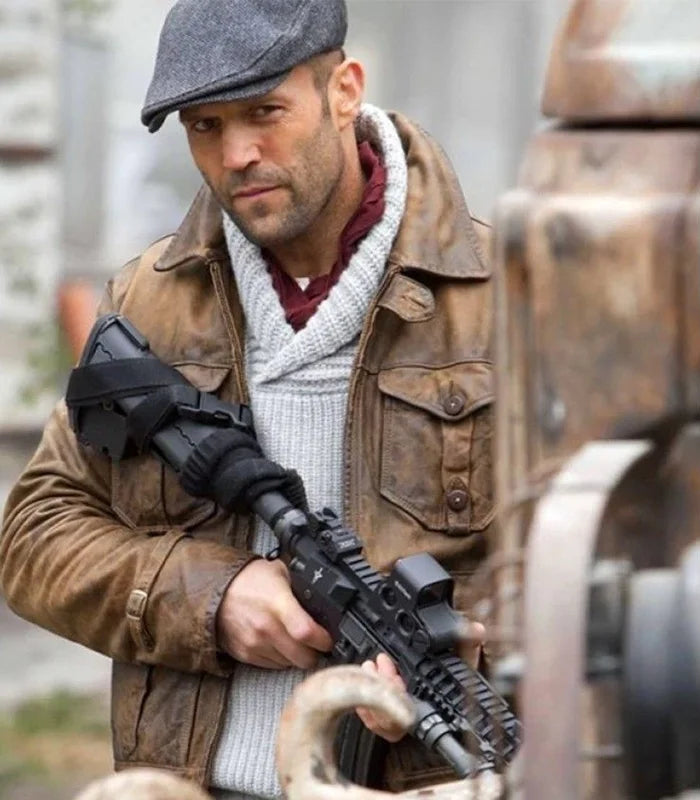Man in a brown jacket and flat cap holding a rifle, with a blurred background